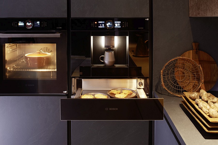 Kaffeevollautomat und darunter geöffnete Wärmeschublade von Bosch