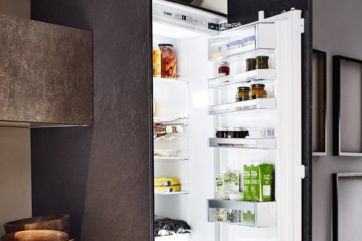 Vollintegrierter, geöffneter Kühlschrank in einer grifflosen, rostbraunen Einbauküche von Nobilia